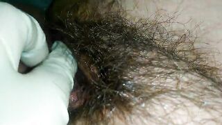 Hairy milf pampers her pussy with latex gloves